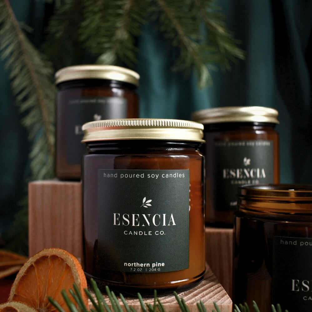 Esecncia Candle Co. candles with decorative elements on a dark background